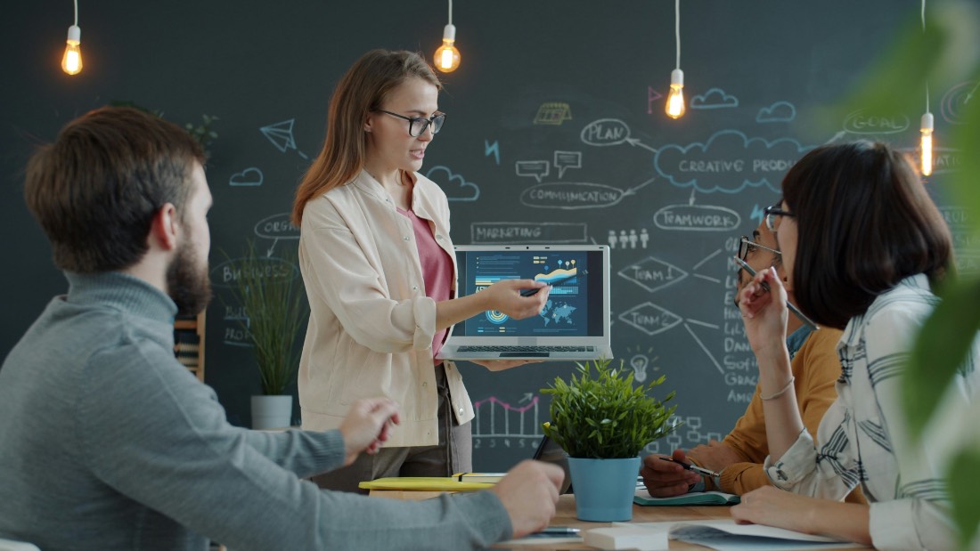 Operations partner walking a creative agency team through workflows on a laptop
